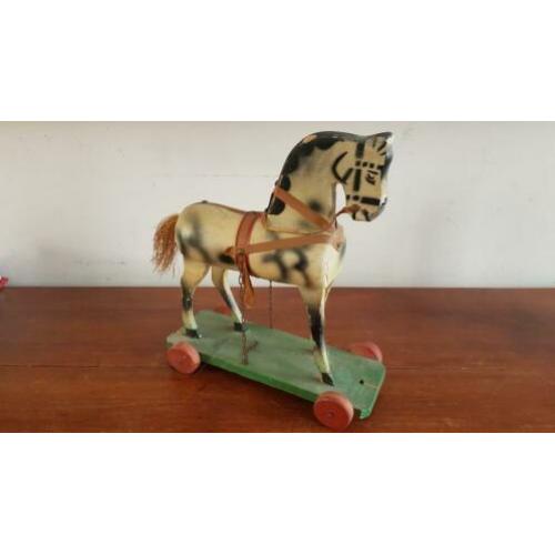 Antiek paard op plankje met wieltjes