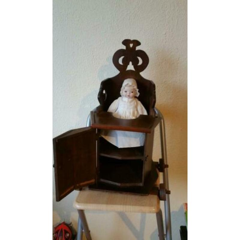 Oude pop in handgemaakt stoeltje