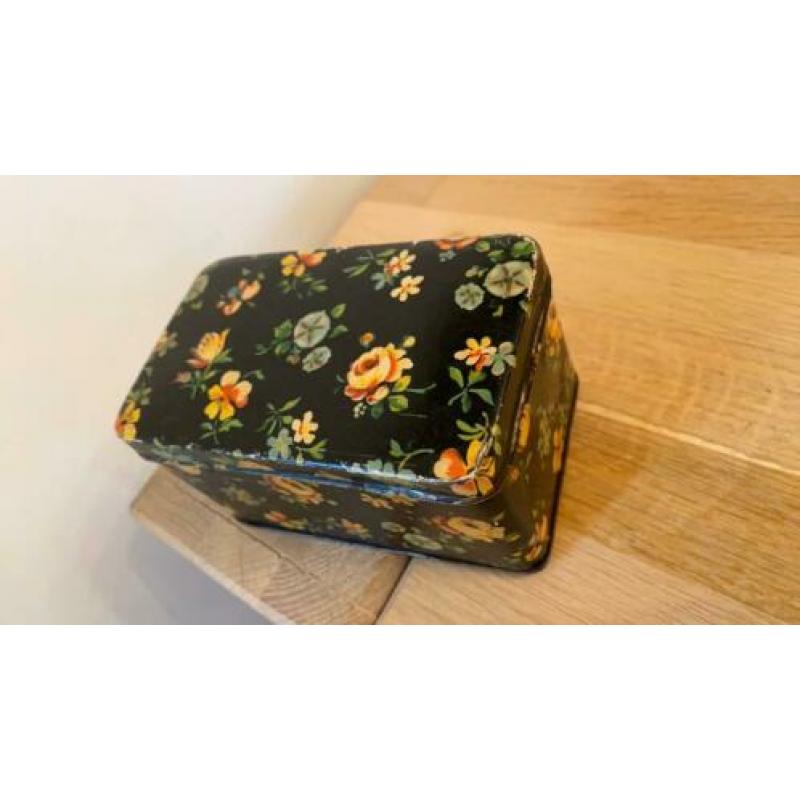 Antiek zwart blikje met gele blauwe bloemen rozen