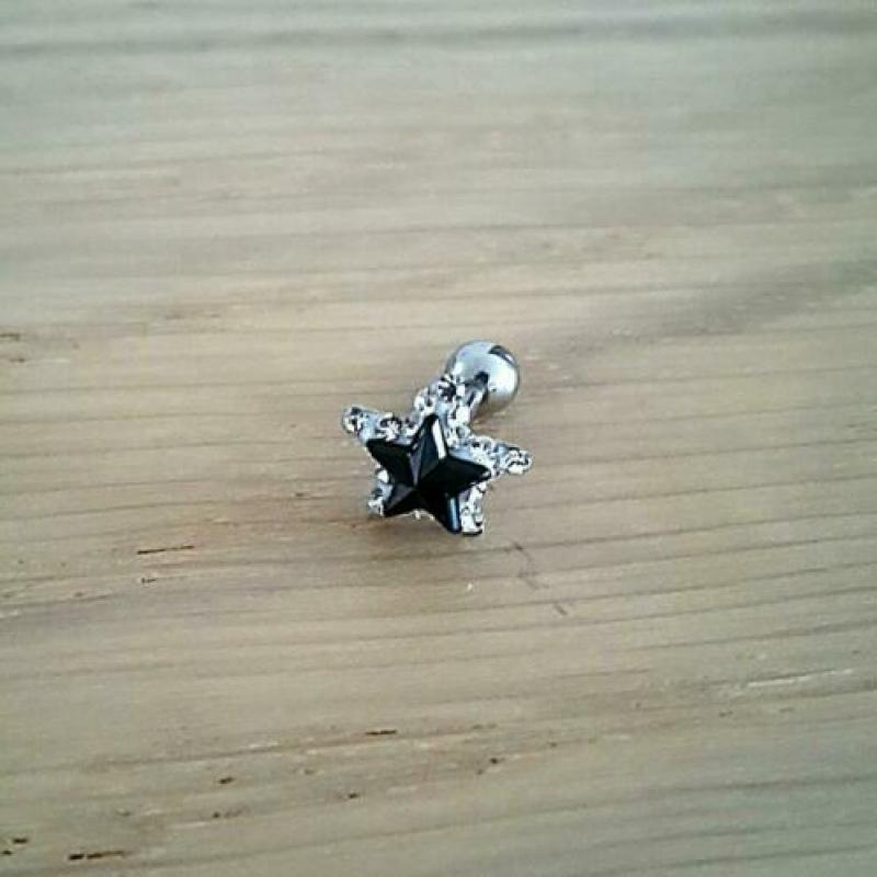 Nieuwe tragus, helix, oorpiercing. Skull, diamant, ster.